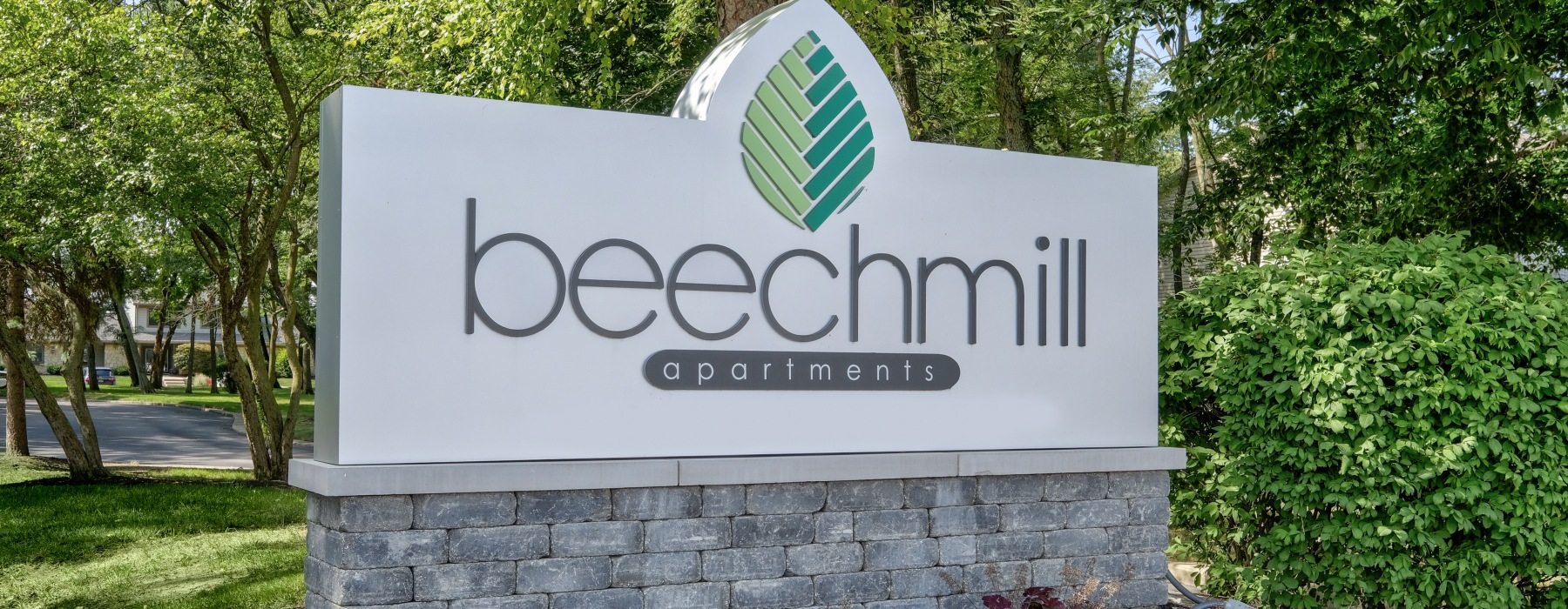 Apartment monument sign with trees